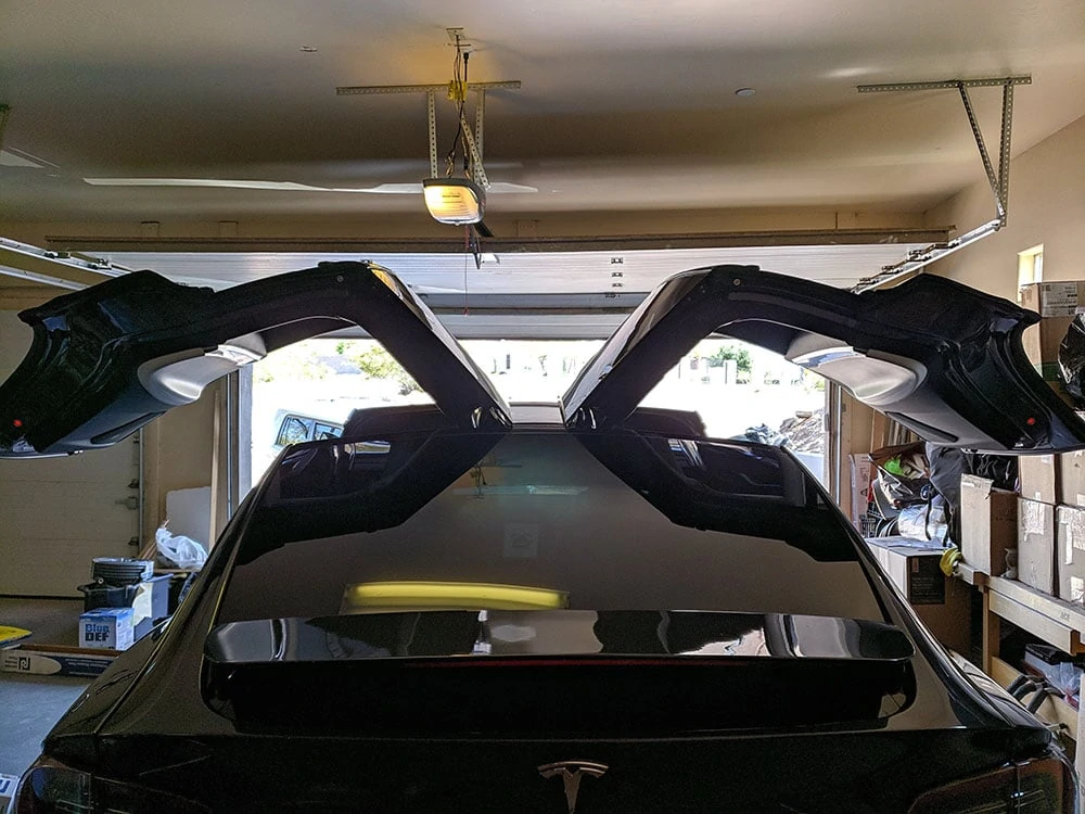 A Tesla with its doors open during a window tint installation